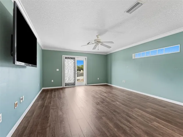 a view of a livingroom with a flat screen tv wooden floor and a ceiling fan