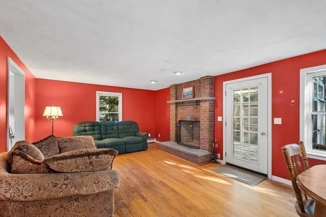 a living room with furniture a fireplace and a large window