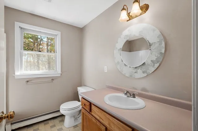 a bathroom with a toilet a sink and mirror