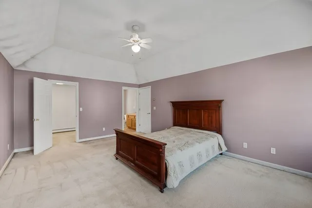 a spacious bedroom with a bed and a chandelier