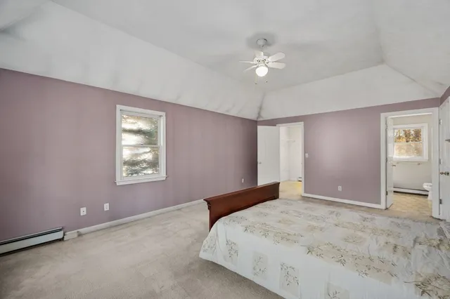 a bedroom with a large bed and a chandelier fan