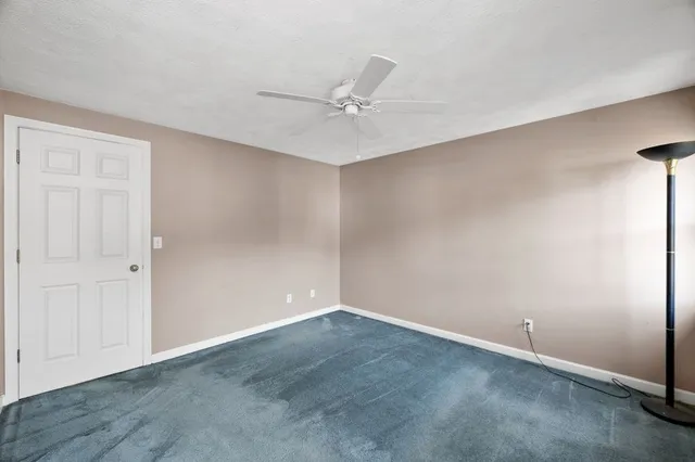 an empty room with a ceiling fan and a window