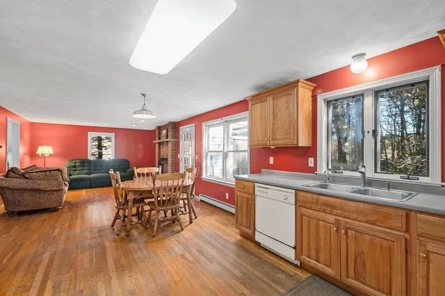 a kitchen with stainless steel appliances granite countertop dining table chairs and wooden floor