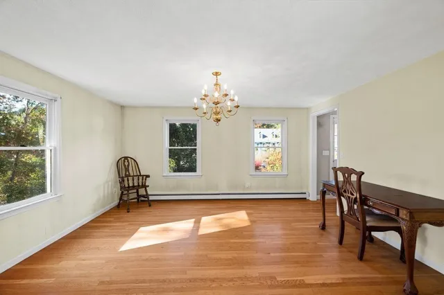 a view of a livingroom with wooden floor and a chandelier