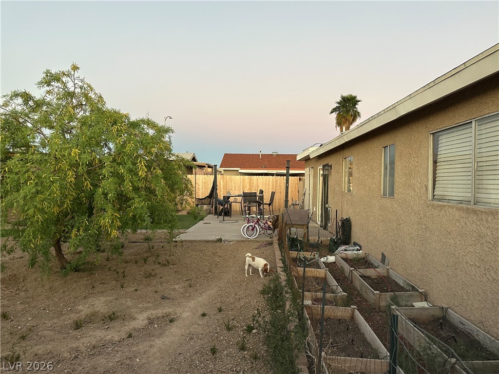 233 Ash Street Henderson, NV 89015 - Photo 18 of 20 Yard at dusk with a patio, a garden, and a fenced backyard