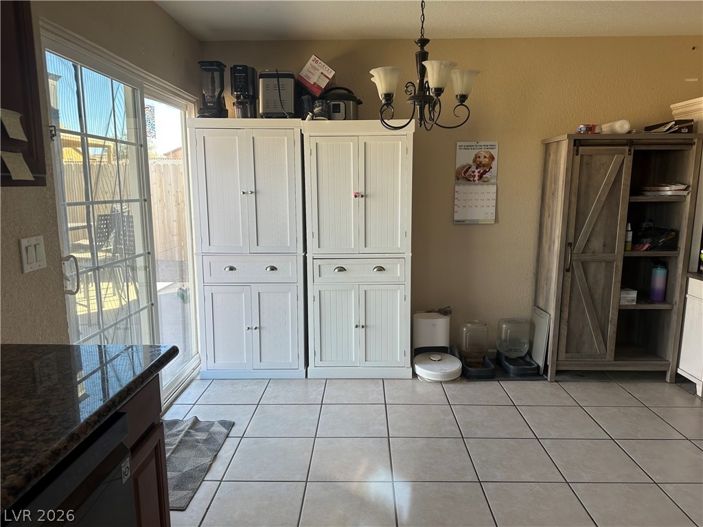 233 Ash Street Henderson, NV 89015 - Photo 5 of 20 Dining space featuring hanging lights, light tile patterned floors, and a textured wall