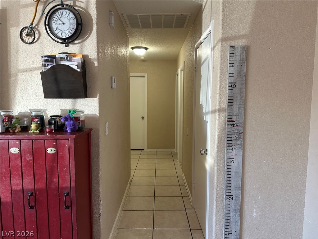 233 Ash Street Henderson, NV 89015 - Photo 6 of 20 Corridor with light tile patterned flooring and a textured wall
