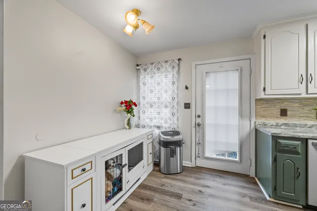 a view of an empty room with a fireplace and wooden floor