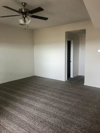 a view of a room with a ceiling fan and a rug