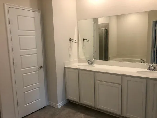 a bathroom with a double vanity sink and a mirror