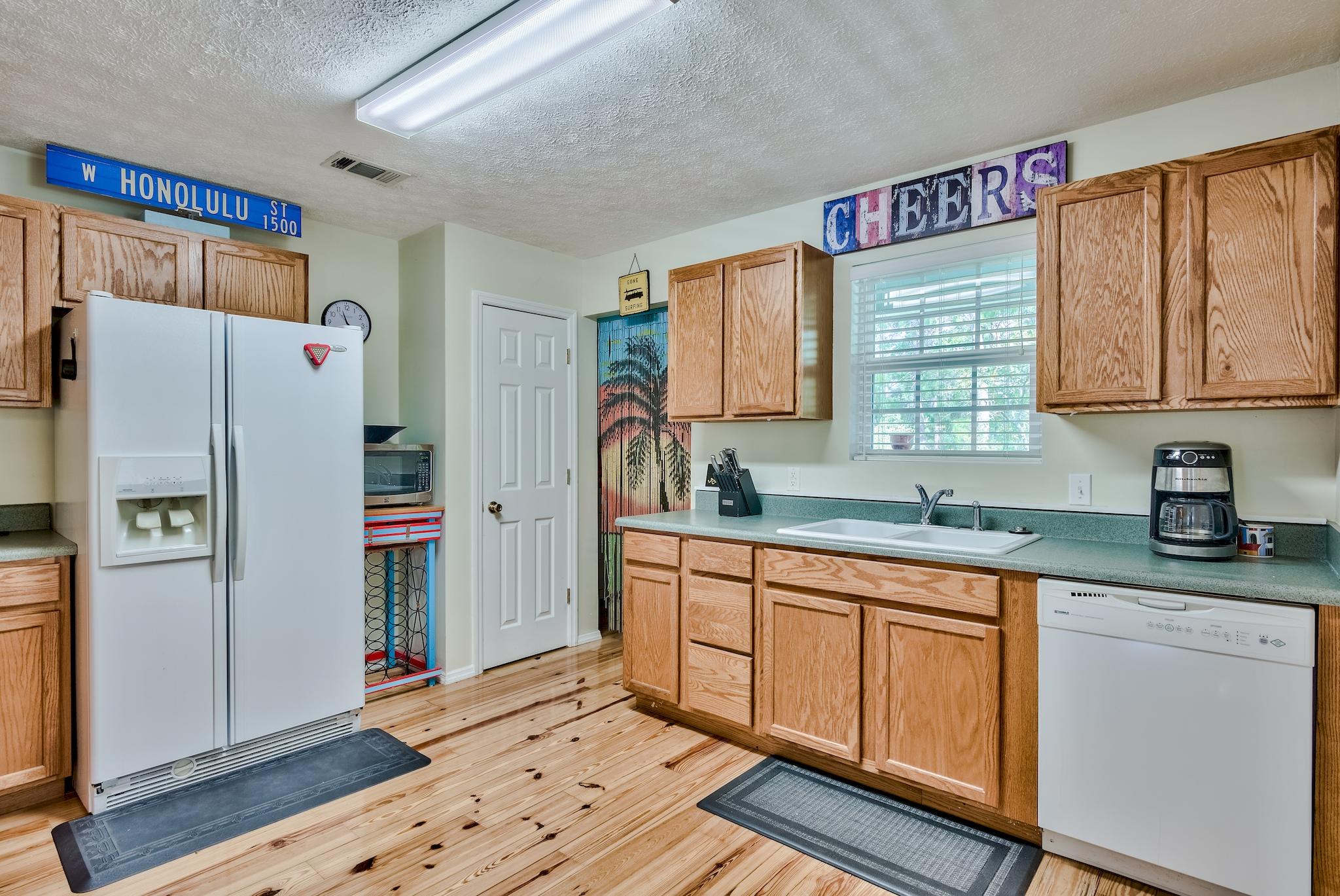 197 Acacia Street Santa Rosa Beach, FL 32459 - Photo 14 of 40 a kitchen with stainless steel appliances a refrigerator sink and cabinets