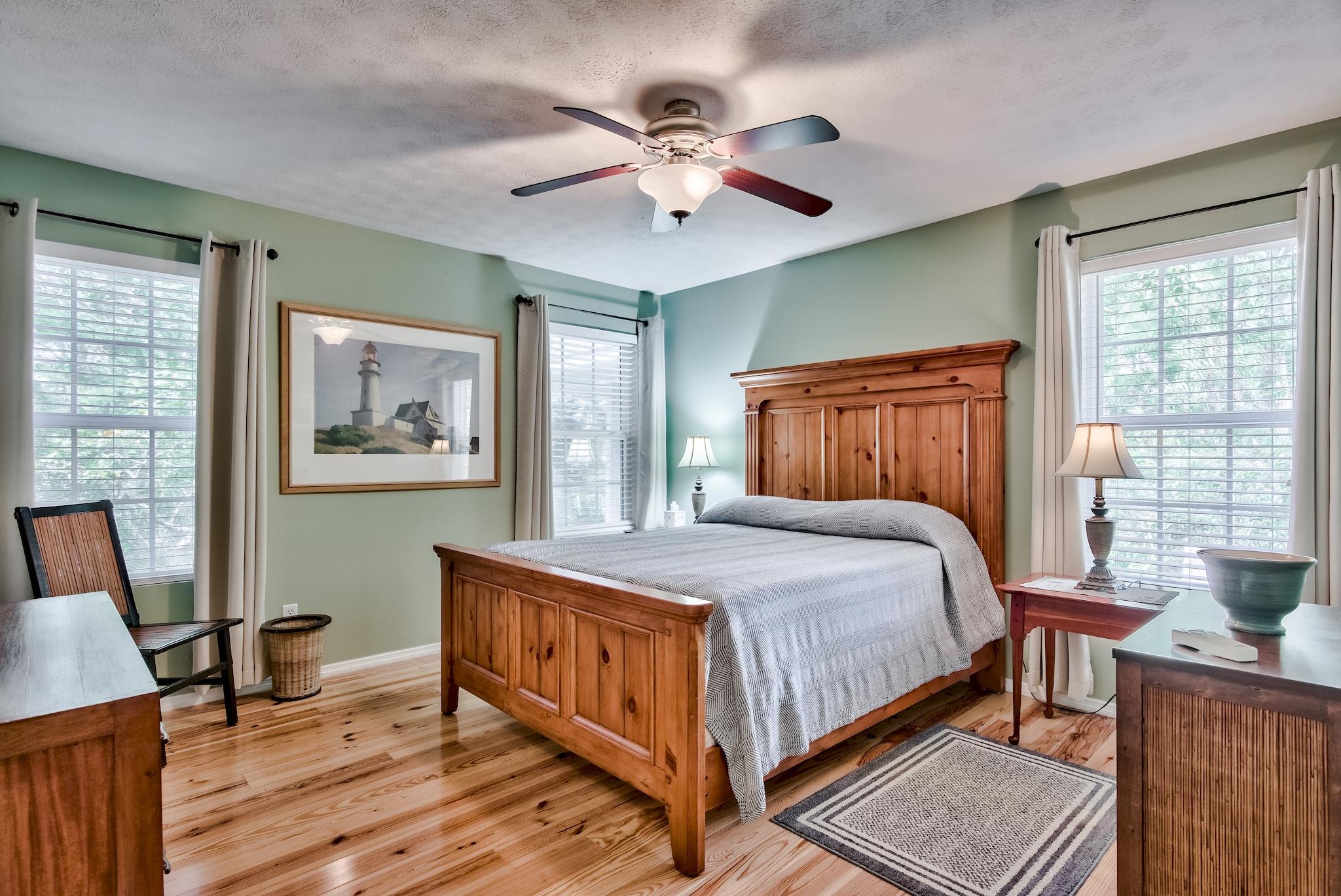 197 Acacia Street Santa Rosa Beach, FL 32459 - Photo 16 of 40 a bedroom with a large bed a desk and chair with a large window