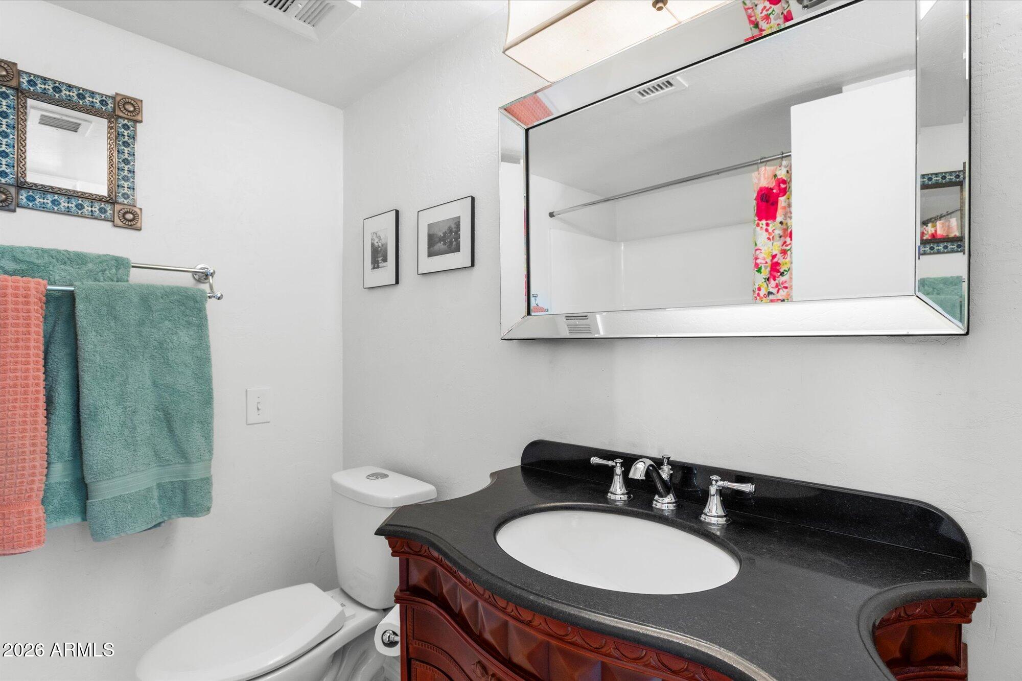 7005 North Barbados Place Phoenix, AZ 85021 - Photo 30 of 42 a bathroom with a sink a toilet and a mirror
