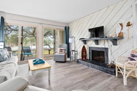 2003 North Fulton Beach Road, Unit 43 Rockport, TX 78382 - Photo 2 of 30 Family room features wood burning fireplace, beautiful wood paneled accent wall,
and vinyl floors through out condominium. New hurricane sliding doors and windows.
