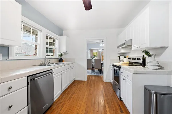 a kitchen with a sink a counter top space stainless steel appliances and a window