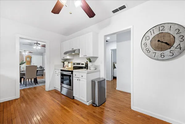 a kitchen with stainless steel appliances granite countertop a refrigerator a stove and a wooden floors