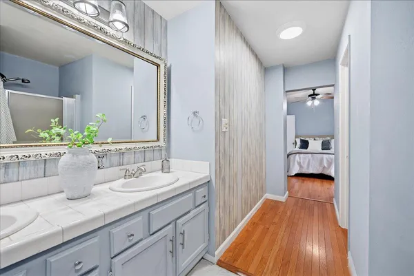 a en suite bathroom with a granite countertop double vanity and a mirror