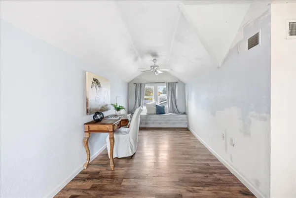 a view of a bedroom with a bed and wooden floor
