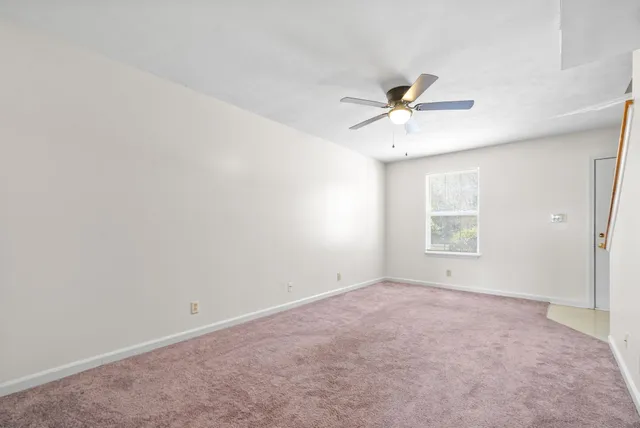 an empty room with a window and a ceiling fan