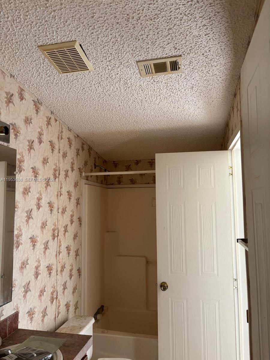 1980 Al Don Farming Road Clewiston, FL 33440 - Photo 19 of 26 a bathroom with a shower curtain and a shower curtain