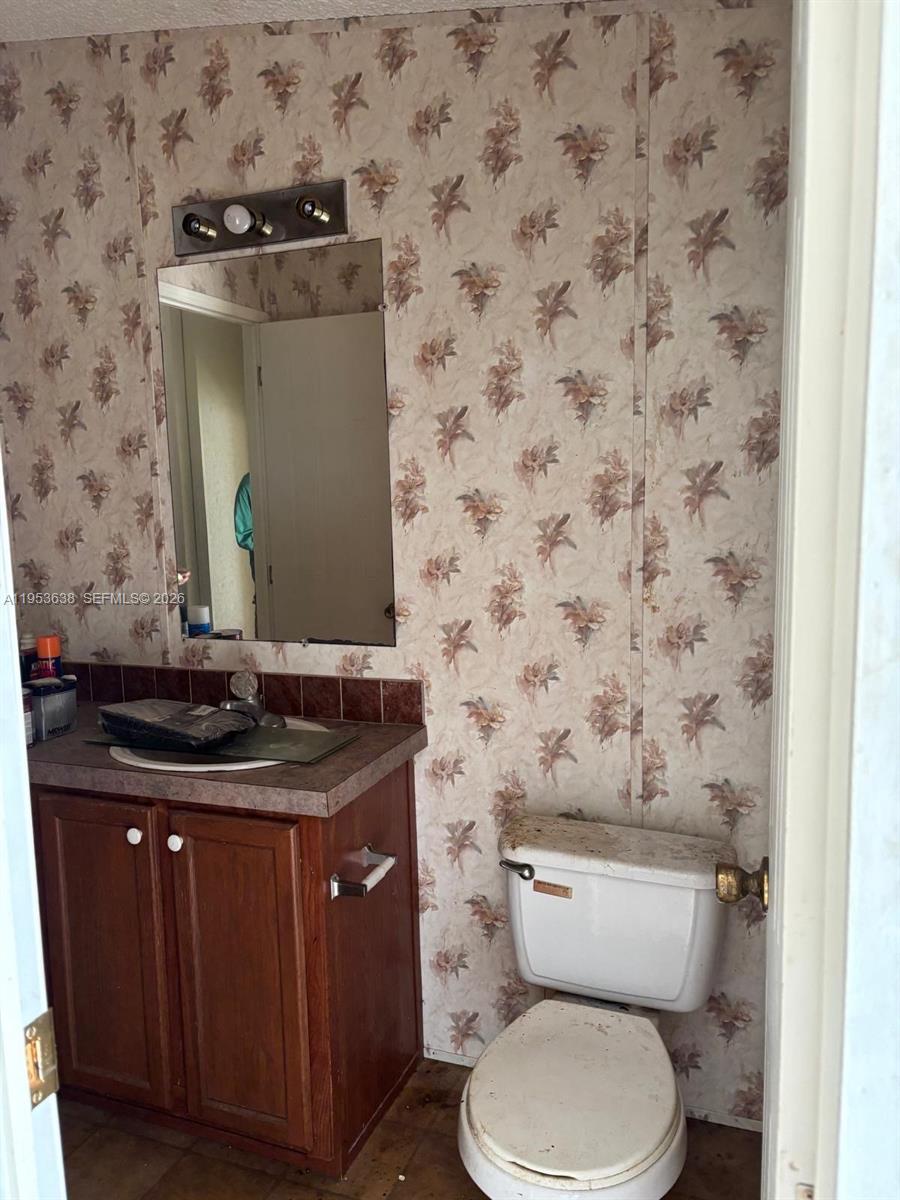 1980 Al Don Farming Road Clewiston, FL 33440 - Photo 20 of 26 a bathroom with a granite countertop toilet sink and mirror