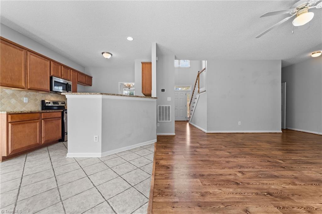 4712 Ridgefall Road Greensboro, NC 27410 - Photo 12 of 44 Living room and breakfast nook area with view of door entrance and kitchen.