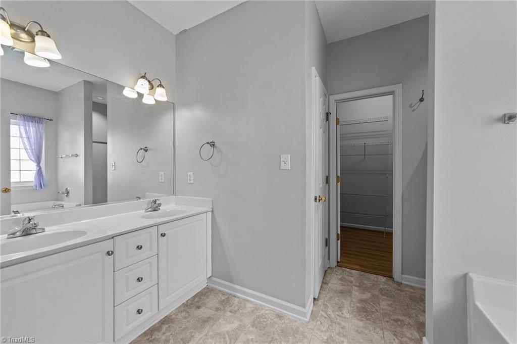 4712 Ridgefall Road Greensboro, NC 27410 - Photo 15 of 44 Primary bath with multiple cabinets and walk-in closet.