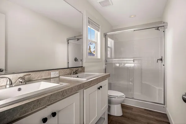 a bathroom with a shower a toilet and a window