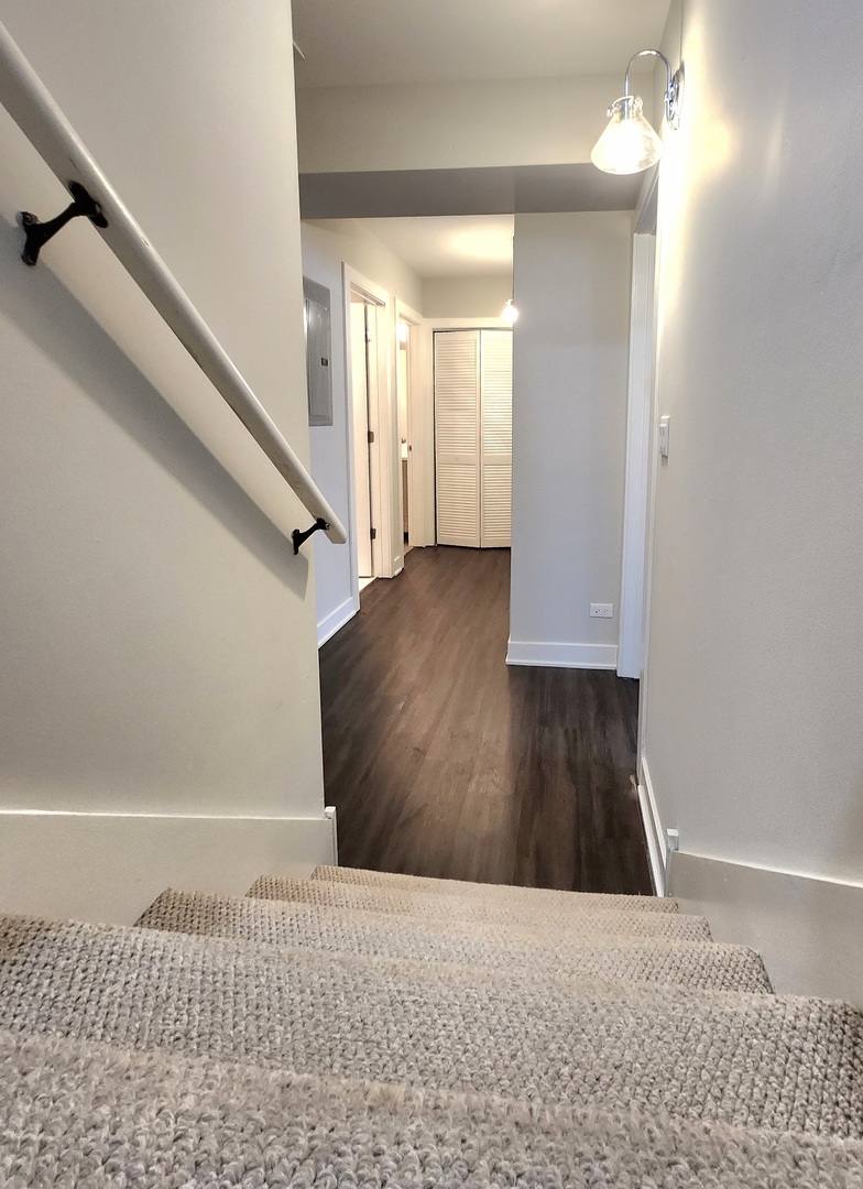 3548 North Racine Avenue, Unit 1 Chicago, IL 60613 - Photo 11 of 19 a view of a hallway view with wooden floor and staircase