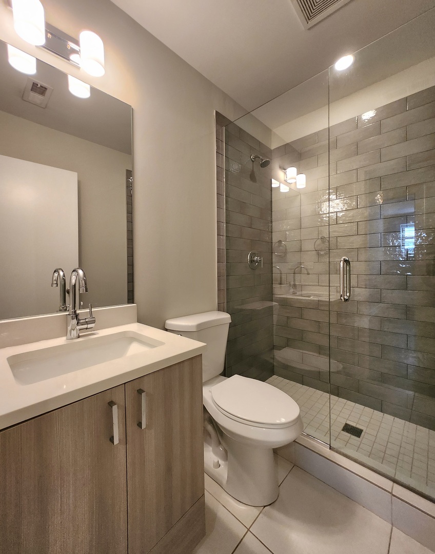 3548 North Racine Avenue, Unit 1 Chicago, IL 60613 - Photo 14 of 19 a bathroom with a sink toilet and shower