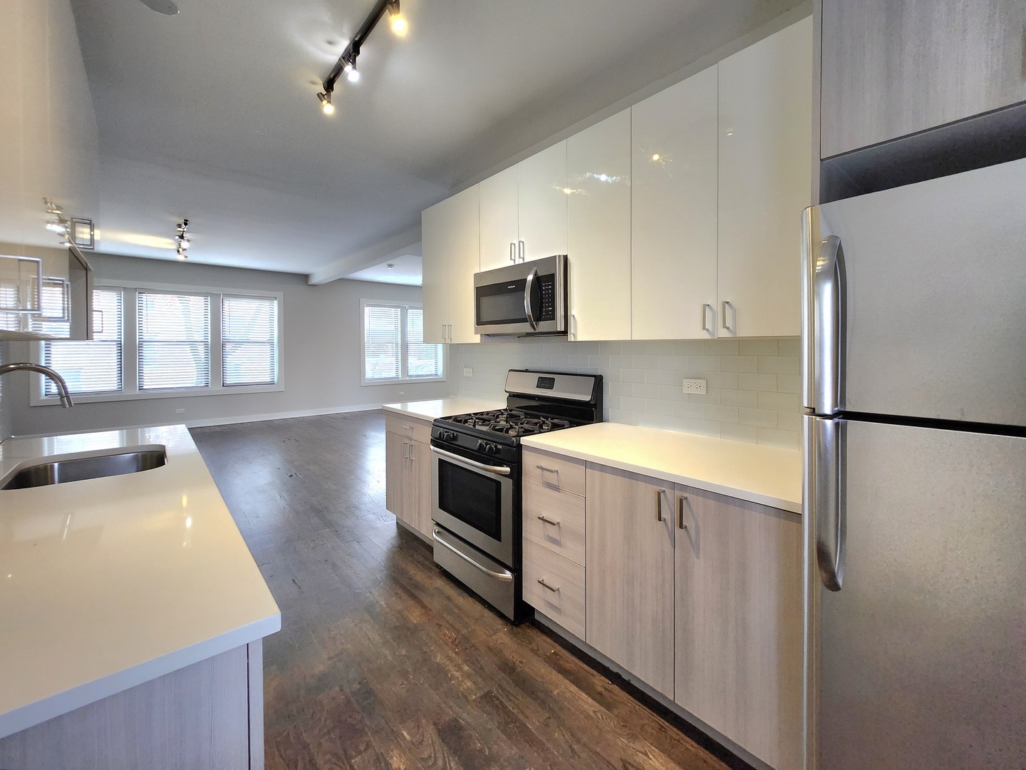 3548 North Racine Avenue, Unit 1 Chicago, IL 60613 - Photo 2 of 19 a kitchen with stainless steel appliances a refrigerator a stove a sink a microwave a refrigerator white cabinets and wooden floor