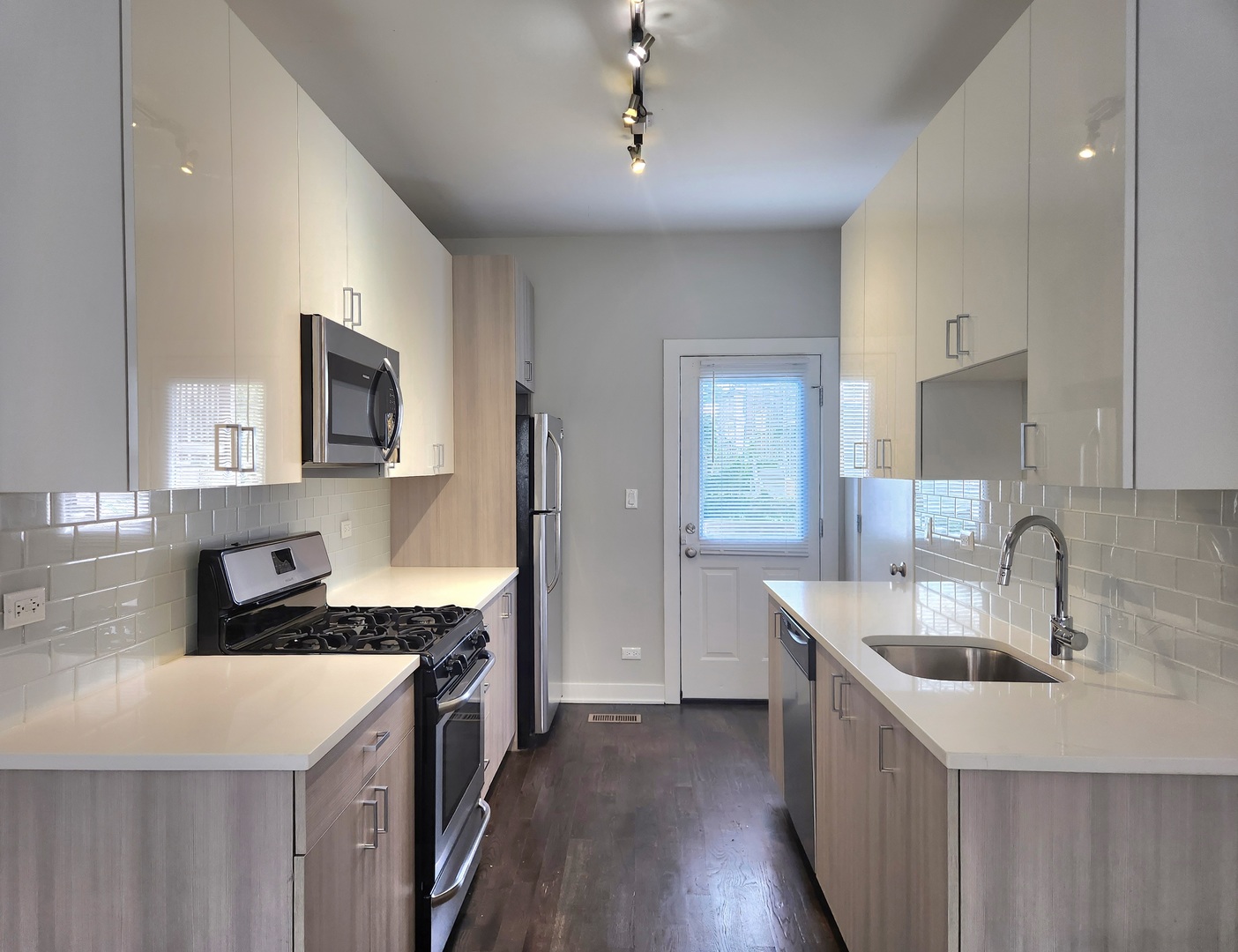 3548 North Racine Avenue, Unit 1 Chicago, IL 60613 - Photo 4 of 19 a kitchen with a sink stove top oven and wooden floor