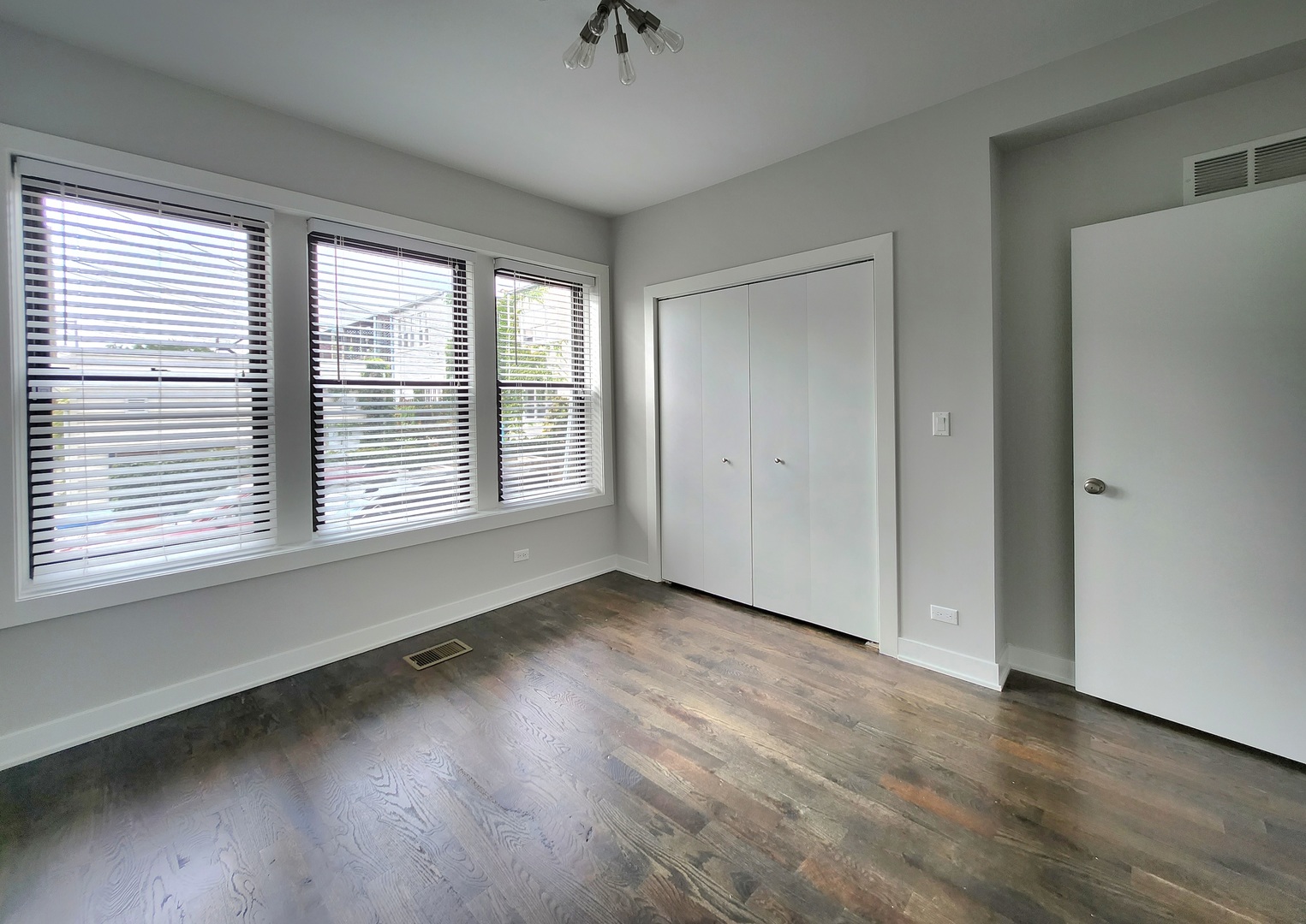 3548 North Racine Avenue, Unit 1 Chicago, IL 60613 - Photo 8 of 19 a view of an empty room with a window and wooden floor
