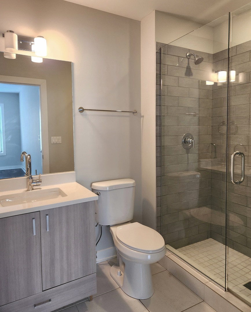 3548 North Racine Avenue, Unit 1 Chicago, IL 60613 - Photo 9 of 19 a bathroom with a sink a toilet and shower