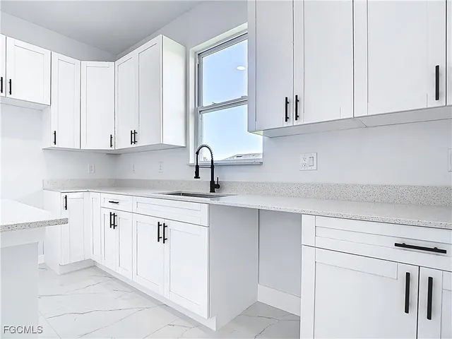 a kitchen with white cabinets and a sink