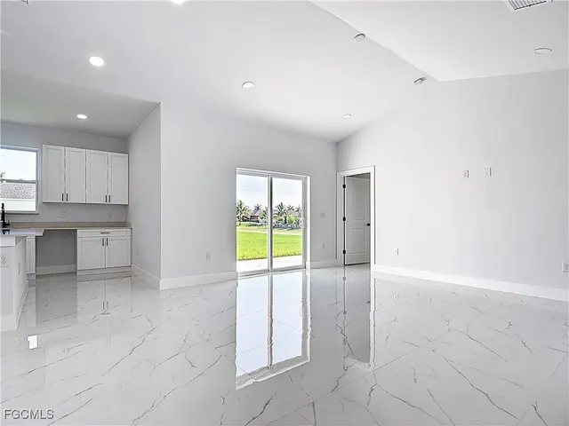 a view of an empty room with a kitchen