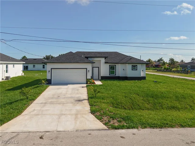 a front view of a house with a yard and garage