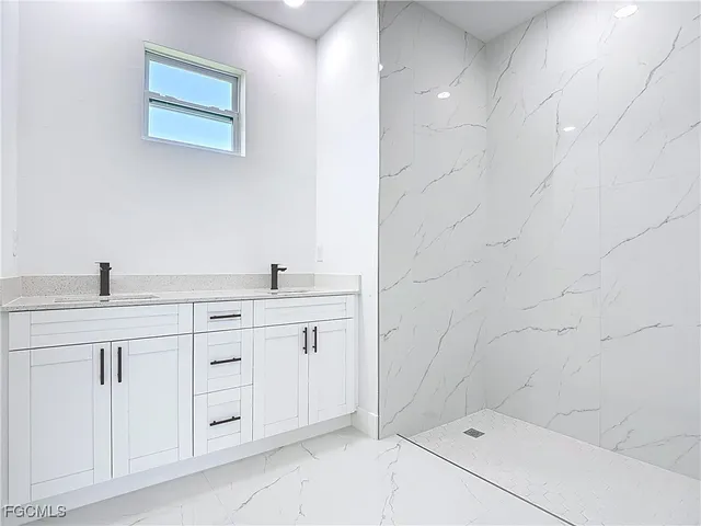 a bathroom with 2 sink shower and a mirror