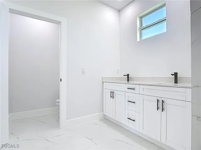 a spacious bathroom with a double vanity sink and a mirror