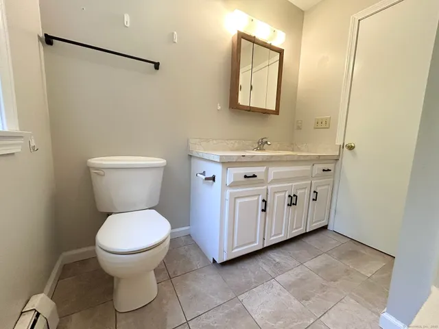 a spacious bathroom with a toilet sink and mirror