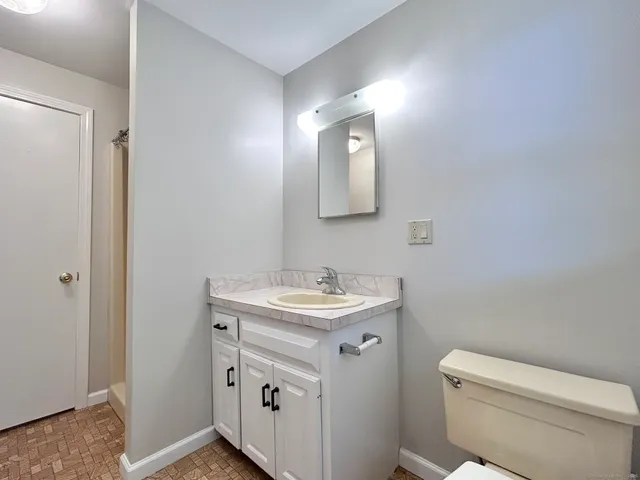 a bathroom with a toilet a sink a vanity and mirror