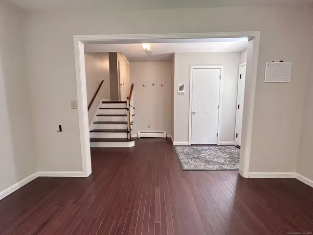 a view of a room with wooden floor and white walls