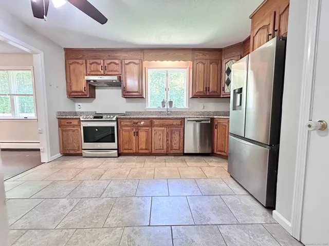 a kitchen with stainless steel appliances granite countertop a refrigerator sink and stove