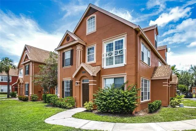 a front view of a house with a yard and trees