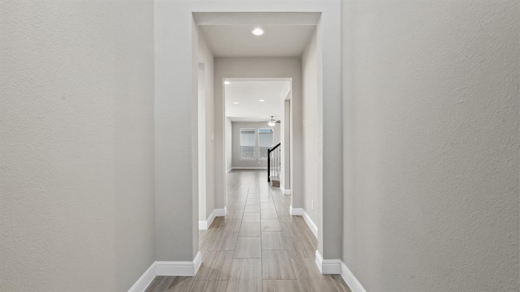 11409 Treehouse Trail Justin, TX 76247 - Photo 16 of 39 a view of a hallway with wooden floor and a bathroom