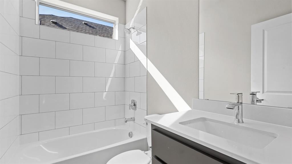 11409 Treehouse Trail Justin, TX 76247 - Photo 20 of 39 a bathroom with a granite countertop sink a toilet and bathtub