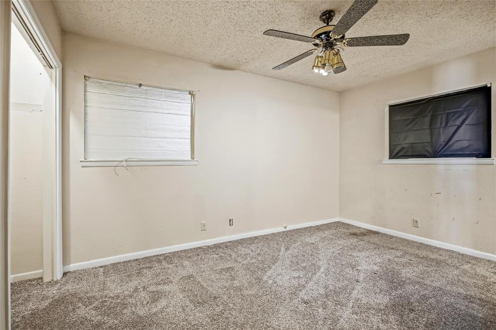 8712 Guadalupe Road Fort Worth, TX 76116 - Photo 16 of 25 an empty room with a chandelier fan and windows
