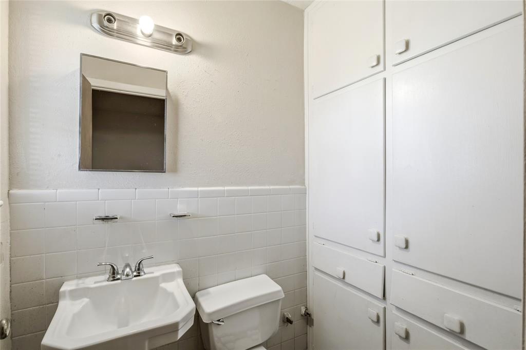 8712 Guadalupe Road Fort Worth, TX 76116 - Photo 18 of 25 a bathroom with a sink a toilet and mirror