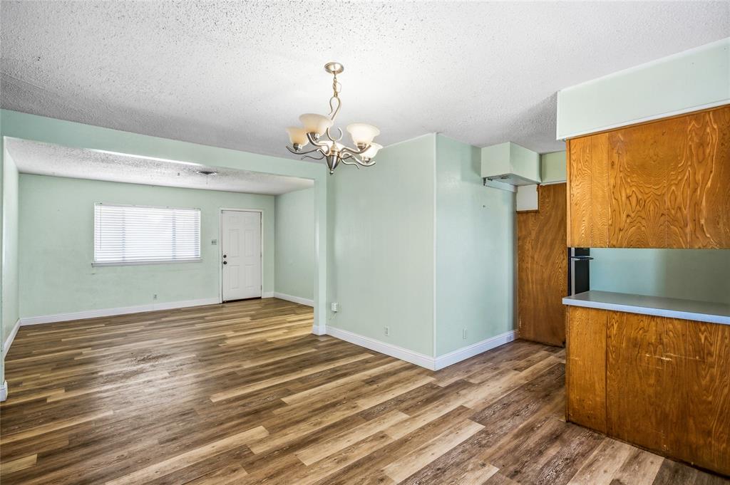 8712 Guadalupe Road Fort Worth, TX 76116 - Photo 20 of 25 a view of a livingroom with wooden floor and chandelier