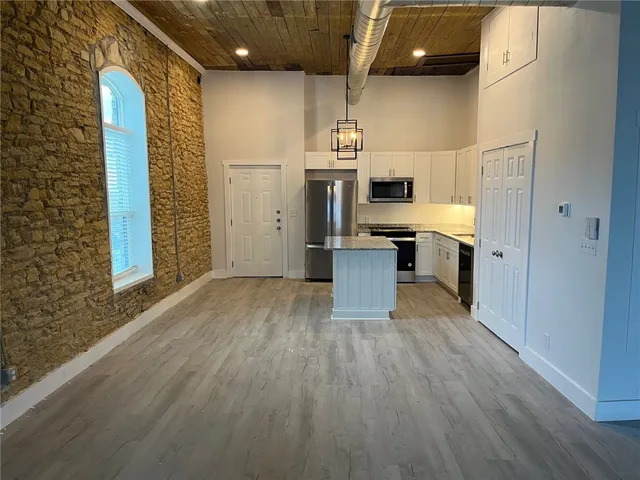 a kitchen with stainless steel appliances a refrigerator and a stove top oven
